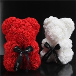 Deux oursons faits de fleurs artificielles, un est rouge et l'autre est blanc, ils sont dans une pièce noire
