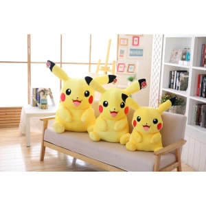 trois pikachus de différentes tailles assis sur un canapé beige dans une belle pièce