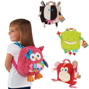 Une fille avec un sac à dos à l'image d'une chouette rose en peluche avec trois autres sacs à dos en peluche à l'image d'une vache, un grenouille et un singe rouge