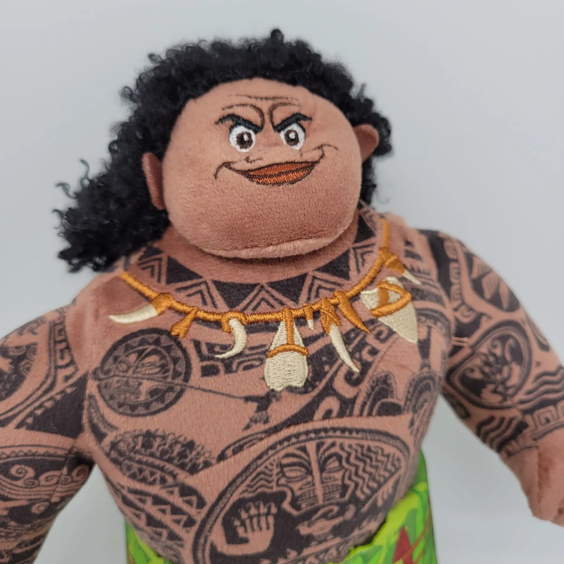 peluche du Personnage Moana Maui du dessin animé de disney on voit sa tête et son buste entièrement tatoué
