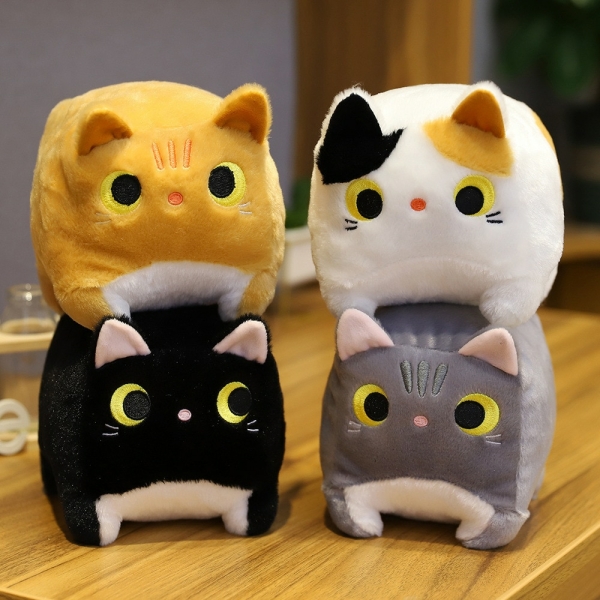 Quatre peluches chat carré posées sur une table en bois. Un chat jaune sur un chat noir et un chat blanc sur un chat gris.