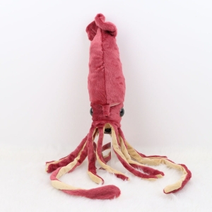 Une peluche pieuvre couleur rose avec de longs tentacules. debout sur un fond blanc.