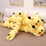 on voit trois peluches coussin xxl de pikachu ensemble sur un lit , elles sont jaunes.