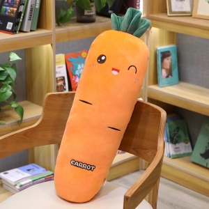 on voit une peluche géante de carotte orange posée sur une chaise, la peluche a un visage avec des yeux et une bouche