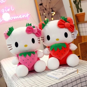 on voit deux peluches Hello Kitty avec une fraise une rose et une rouge sur une table avec une nappe à carreaux
